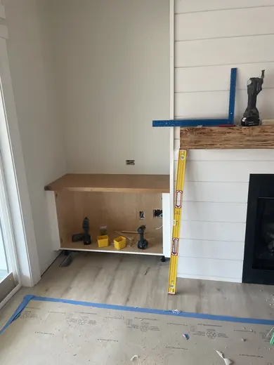 White plank ceilings, exposed wood beams, white cabinetry and a shiplap fireplace, view 4.