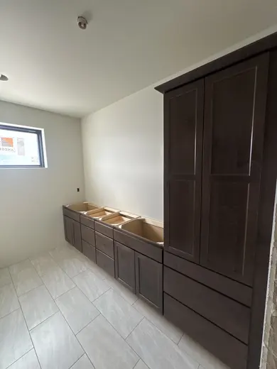 Tall linen cabinets and vanity cabinetry beside the tiled bathing area, view 1.