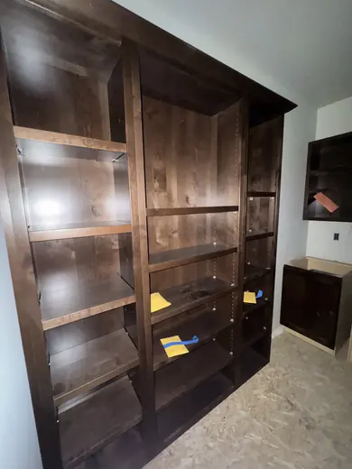 Dark wood kitchen and pantry cabinetry, sliding pantry doors, a green entry bench and adjacent stair-skirt details, view 3.