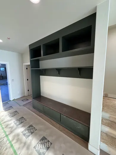 Dark wood kitchen and pantry cabinetry, sliding pantry doors, a green entry bench and adjacent stair-skirt details, view 16.