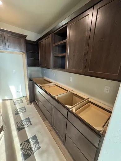 Dark wood kitchen and pantry cabinetry, sliding pantry doors, a green entry bench and adjacent stair-skirt details, view 6.