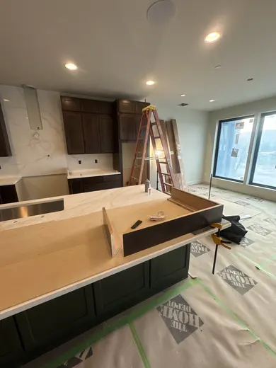 Dark wood kitchen and pantry cabinetry, sliding pantry doors, a green entry bench and adjacent stair-skirt details, view 7.