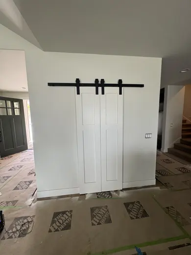 Dark wood kitchen and pantry cabinetry, sliding pantry doors, a green entry bench and adjacent stair-skirt details, view 12.