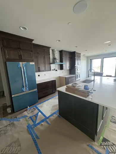 Dark wood kitchen and pantry cabinetry, sliding pantry doors, a green entry bench and adjacent stair-skirt details, view 13.