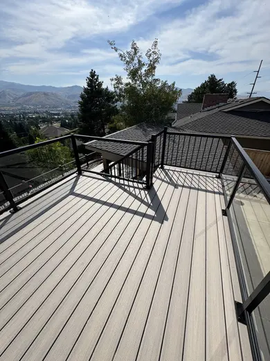 Pale decking, glass panels and black metal stair railings around the same outdoor space, view 5.