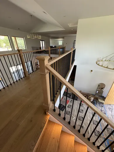 Wood treads, substantial newel posts, black balusters and warm step lighting, view 12.