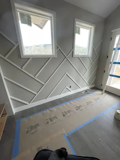 Diagonal applied wall trim between two tall windows, view 1.