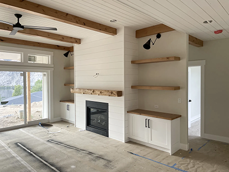 White plank ceilings, exposed wood beams, white cabinetry and a shiplap fireplace, view 9.