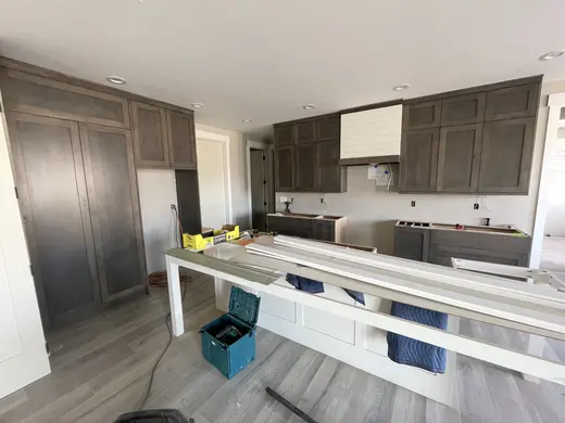 Gray shaker cabinetry at two stages of the same kitchen installation, view 2.