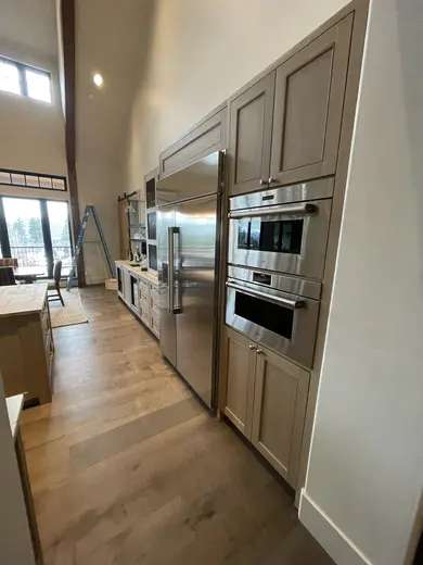 Gray wood cabinetry, mesh cabinet doors, appliance surrounds and beverage storage, view 3.