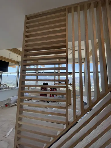 Intersecting wood slats beside the staircase, with wider installation views, view 3.