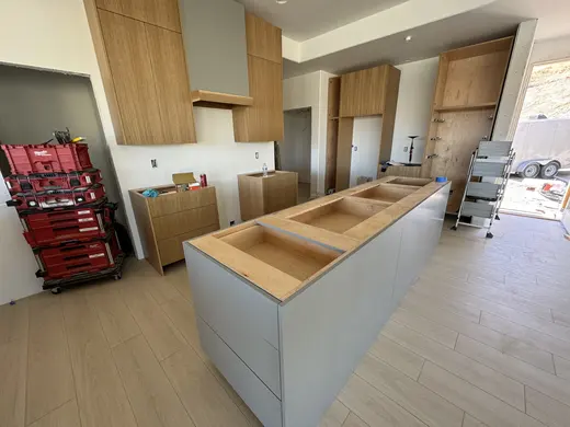 Slab wood cabinets, a gray island and a recessed wood-trimmed niche, view 4.
