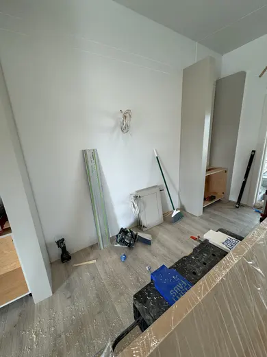 Fluted fireplace wall with side cabinets and shelves at successive installation stages, view 1.