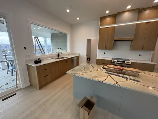Slab wood cabinets, a gray island and a recessed wood-trimmed niche, view 13.