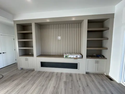Fluted fireplace wall with side cabinets and shelves at successive installation stages, view 7.