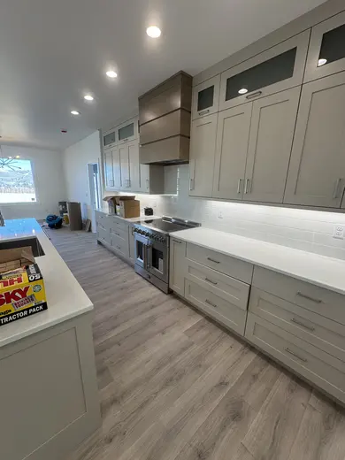 Gray cabinetry, refrigerator surround, bottle storage and a wood hood, view 3.
